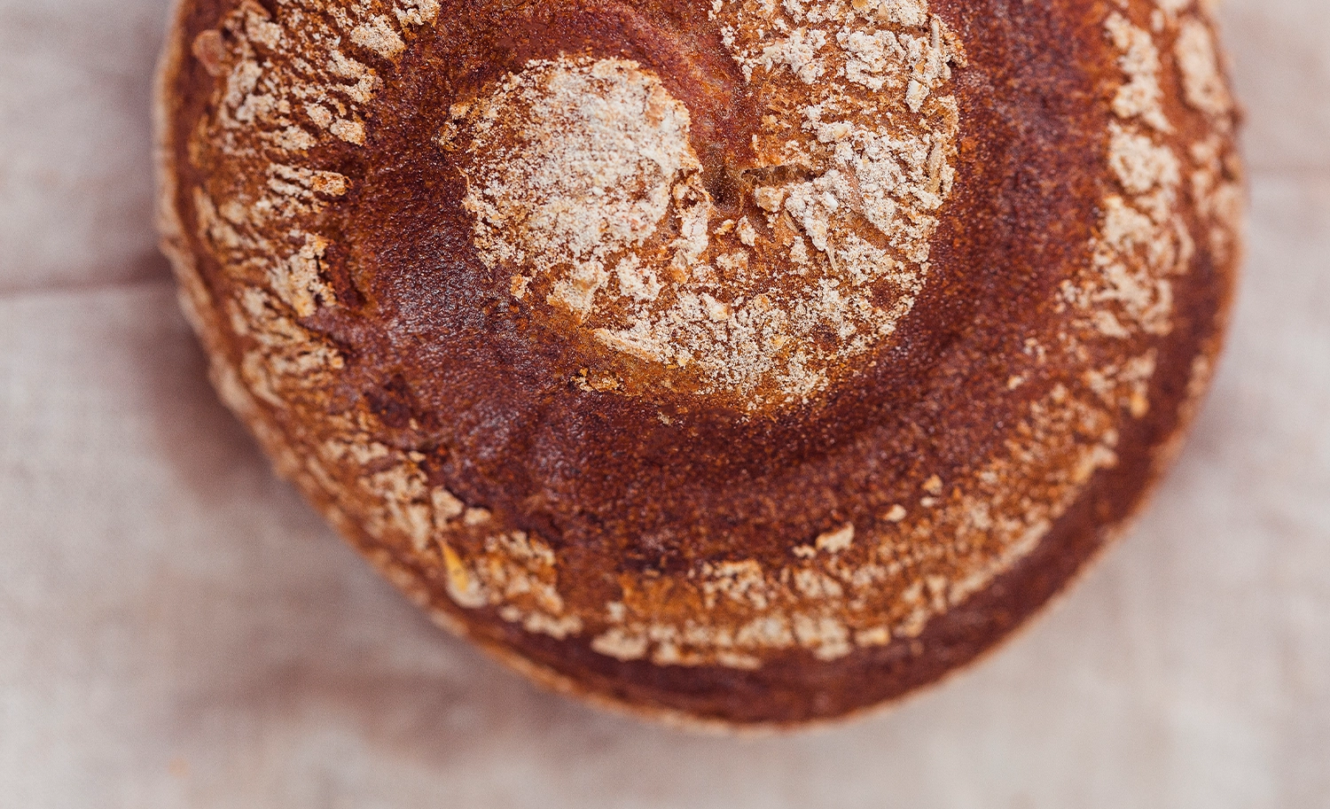 Reine Roggensemmel in kunstvoller Schneckenform auf einem Leinentuch drapiert. Ein Klassiker der Bäckerei Müller