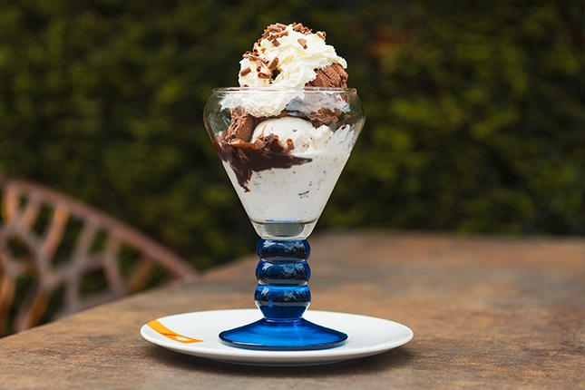 Schokoladen-Eisbecher der Bäckerei Müller mit großer Sahnehaube und Schokoladenstreuseln.