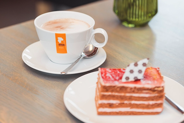 Heiße Schokolade und ein geschichteter Erdbeerkuchen mit Fußballschokochip als Garnitur passend zur EM.