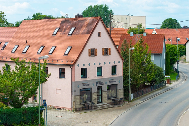 Außenaufnahme der Filiale in Wehringen. Zu sehen ist der Eingangsbereich mit Treppenstufen über die man in die Filiale gelangt.