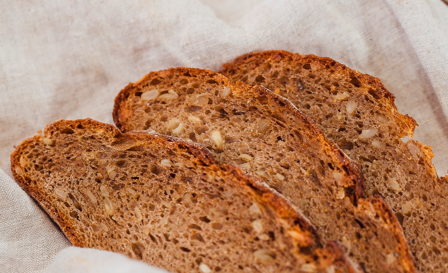 Frisches Dinkel-Vollkornbrot der Bäckerei Müller, das aufgeschnitten auf einem Leinentuch drapiert liegt