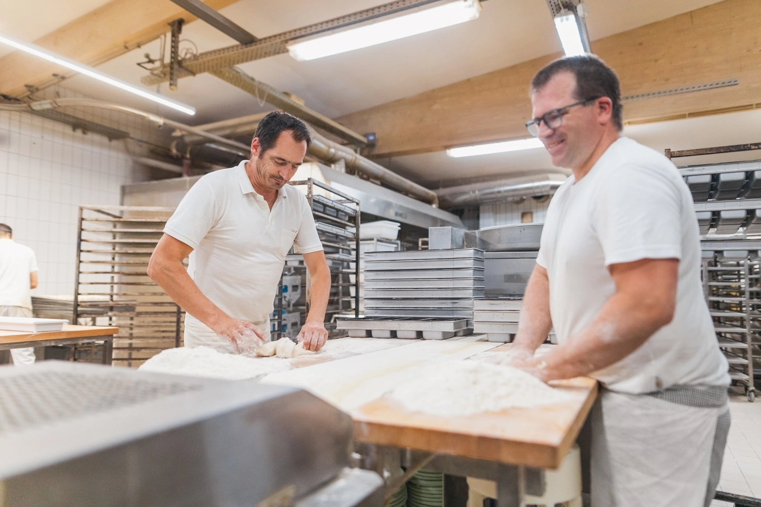 Zwei Bäcker in der Backstube der Bäckerei Müller beim Ausführen ihres Backhandwerks