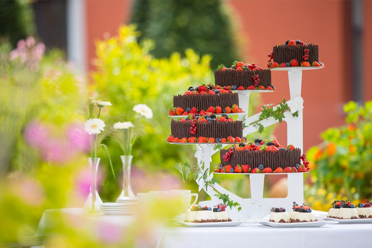 Hochzeitstorte mit einer Komposition aus Beeren wie Erd-, Blau-, Brom- und Johannisbeeren, gepaart mit fein gerollten Schokoladenstiften und auf Schokoladensplittern gebettet. Die Torte ist auf insgesamt fünf Etagen verteilt